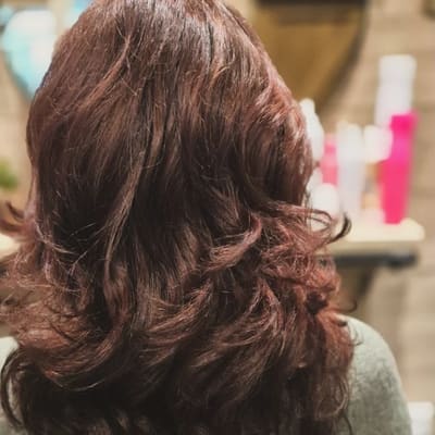 Na: hetzelfde haar in een warme roodbruine kleur, met volume geföhnd.