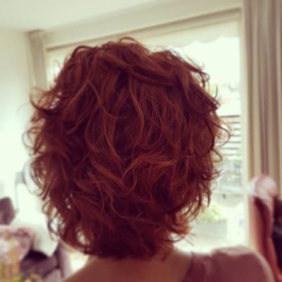 Halflange rode krullen, van achteren gezien.