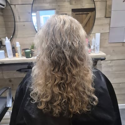 Voor: blond, golvend haar met pluis, van achteren gezien.
